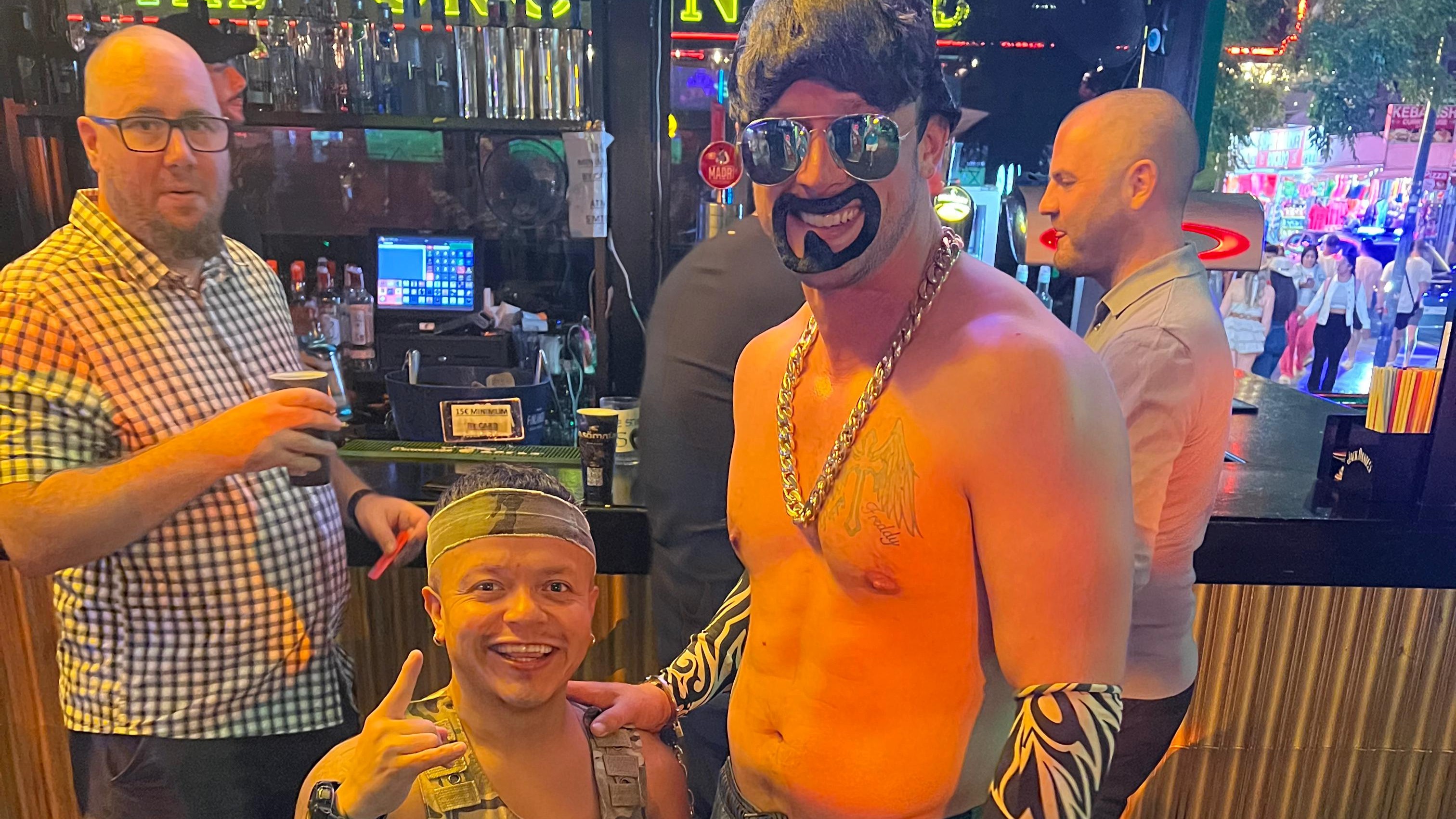 Stag do group enjoying Benidorm nightlife with dwarf handcuff prank